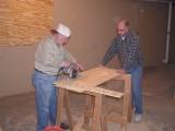 Jim Dick and John Thomas prepare the plywood for the windows.